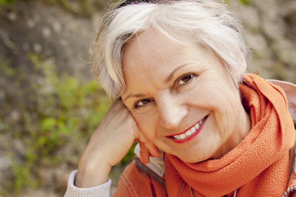 An older woman in a scarf smiles